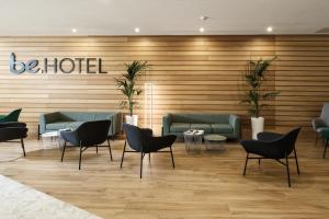 a lobby with couches and chairs and a sign that reads be hotel at be.HOTEL in St. Julianʼs