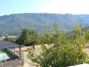 a villa with a swimming pool and mountains in the background at Chambres d'hôtes Le Prieuré in Noyers-sur-Jabron