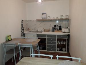 a kitchen with a table and chairs and a counter at Chambres d'hôtes Le Prieuré in Noyers-sur-Jabron