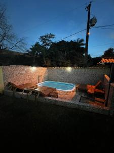 a pool with a table and two chairs and a table and a patio at Nova Beco das Cores Flats e Pousada in Serra do Cipo