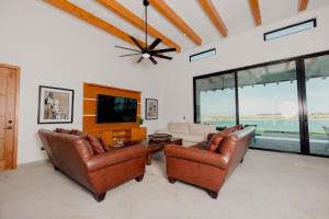 a living room with two leather chairs and a tv at Adora House in Puerto Peñasco