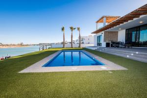 a house with a swimming pool next to the water at Adora House in Puerto Peñasco