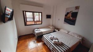 a small room with two beds and a couch at HABITACIONES en casa palermo con terraza y parrilla in Buenos Aires