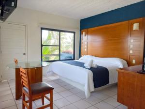 um quarto com uma cama, uma mesa e uma janela em HOTEL TORRE MARINA em Monte Gordo
