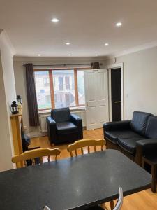 a living room with a black table and chairs at 2 bed cosy apartment in heart of Mullingar. in Mullingar