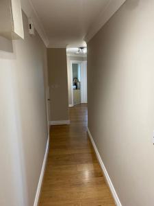 an empty hallway with white walls and a wooden floor at 2 bed cosy apartment in heart of Mullingar. in Mullingar