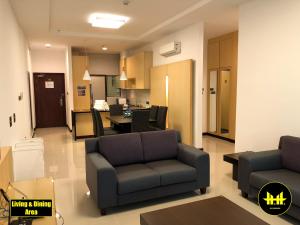 a living room with a couch and a dining room at VACA Apartments at Imperial Suites in Kuching