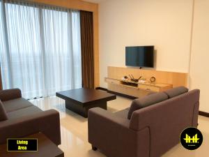 a living room with two couches and a flat screen tv at VACA Apartments at Imperial Suites in Kuching
