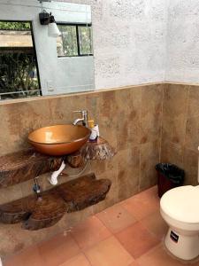 y baño con lavabo de madera y aseo. en Casa de Campo Nuestra Tierra, en Quito