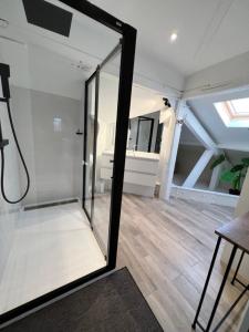 um chuveiro de vidro num quarto com piso de madeira em DUPLEX AVENUE ROYALE em Compiègne