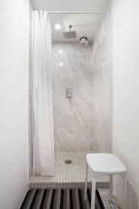 y baño con ducha blanca y taburete blanco. en Linda Habitacion privada con balcon en Polanco, en Ciudad de México