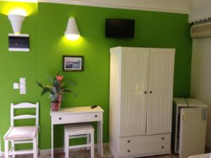 a green room with a desk and a cabinet at Villa Michalis in Vlychada