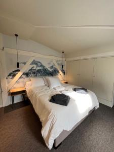 DUPLEX AVENUE ROYALE في كومبيان: غرفة نوم مع سرير أبيض كبير مع لوحة على الحائط