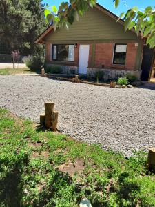 uma casa com uma entrada de cascalho em frente a uma casa em Escallonia House em San Martín de los Andes