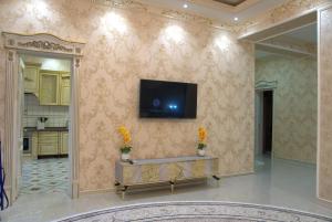 uma sala de estar com uma televisão na parede em Казахстан 13 em Tashkent