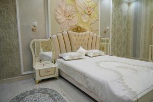 a bedroom with a white bed with a flower headboard at Казахстан 13 in Tashkent