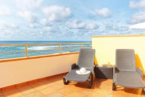 two chairs on a balcony overlooking the ocean at Apartamentos Maype Canteras in Las Palmas de Gran Canaria