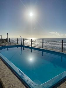 a large swimming pool next to the beach at Casa de praia em condomínio à beira mar in Barra de São Miguel