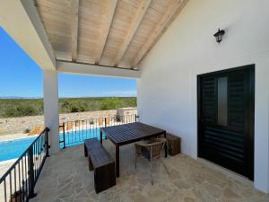 une terrasse avec une table et une piscine dans l'établissement Villa Maslina Šarić, à Ðevrske