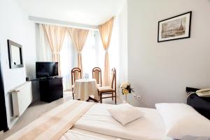 a bedroom with a bed and a table and chairs at Astoria Hotel & Restaurant in Gheorgheni