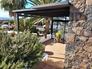 een patio met potplanten en een stenen muur bij Apartamento con terraza y jardín in Las Breñas