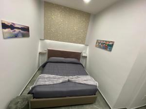 ein kleines Schlafzimmer mit einem Bett in der Ecke in der Unterkunft Maison Quartieri Spagnoli in Neapel