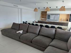 un sofá marrón en una sala de estar con cocina en CASA MARISA, en Alcanar