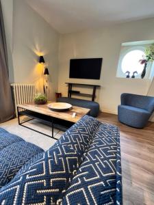 DUPLEX AVENUE ROYALE في كومبيان: غرفة معيشة مع سرير وطاولة وتلفزيون