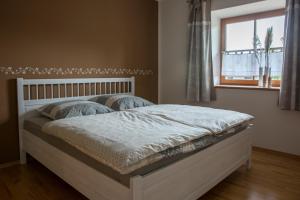 a white bed in a bedroom with a window at Bio-Bauernhof Eisele in Scheuring