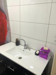 a bathroom sink with a purple bag on it at Very nice apartment with view of all the old city in Jerusalem