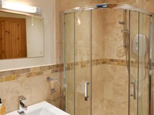 een badkamer met een douche, een wastafel en een spiegel bij Pitcairn House-uk41255 in Keswick