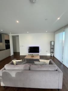 a living room with a large couch in the middle at Immaculate 2bed apartment in London- city views in London