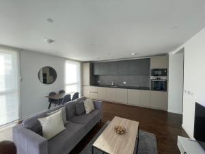 a living room with a couch and a table at Immaculate 2bed apartment in London- city views in London
