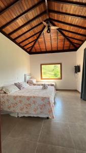 - une chambre avec un grand lit et un plafond en bois dans l'établissement Casa Cambuí Hospedagem Rural, à Rio Preto