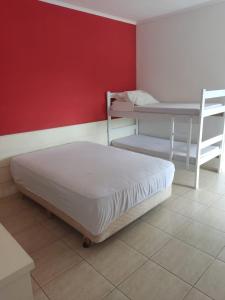 a room with a bed and a table and a bed and a bed at Casa Ampla e confortável in São Sebastião