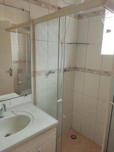 a bathroom with a sink and a glass shower at Casa Ampla e confortável in São Sebastião