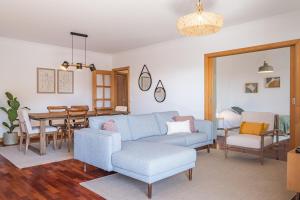 a living room with a blue couch and a table at Pateo do Carmo - By Wehost in Funchal