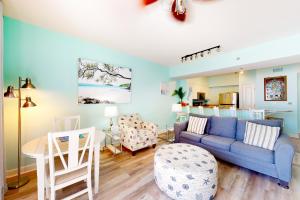 a living room with a blue couch and a table at Shores of Panama, Unit #1415 in Panama City Beach