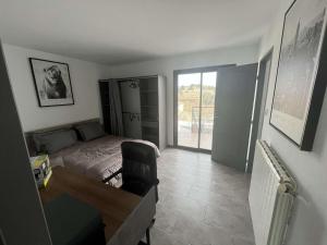 - une chambre avec un lit et un bureau avec une chaise dans l'établissement Superbe appartement avec piscine et spa privatif, à Villeneuve-lès-Béziers