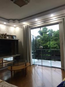 una sala de estar con una gran puerta corredera de cristal en Residencial Jardim Curitiba, en Curitiba