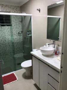 W łazience znajduje się toaleta, umywalka i prysznic. w obiekcie Residencial Jardim Curitiba w mieście Kurytyba