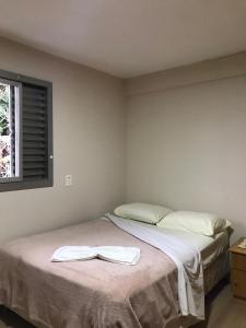Un dormitorio con una cama con una toalla. en Residencial Jardim Curitiba, en Curitiba