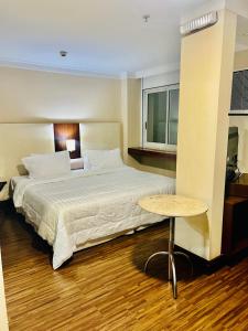 una habitación de hotel con una cama grande y una mesa en Hotel International Plaza Alameda Santos SP, en São Paulo
