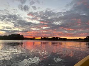 un coucher de soleil sur une grande étendue d'eau dans l'établissement Tarula Holiday Home, à Melkoniemi