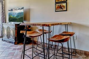 a wooden bar with stools in a room at OLDE GATLINBURG PLACE UNIT 510 - GREAT LOCATION! CLOSE TO TOWN! condo in Gatlinburg +14 photos