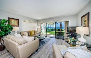 a living room with a couch and a tv at Beachfront Aldea 5 in Clearwater Beach
