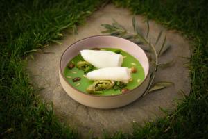 a bowl of food with cheese and vegetables in the grass at Best Western Plus Sabaudia Hotel in Sabaudia