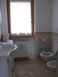 baño con lavabo y aseo y ventana en le balze di Carisolo, trilocale con giardino, en Carisolo