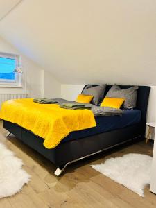 a bedroom with a bed with a yellow blanket at Idyllische Suite in Zentrumsnähe mit Parkplatz Top 1 in Gmunden