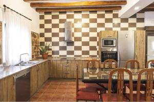 a kitchen with a checkered wall at La Casa de los Dos Rubios in Nava de la Asunción